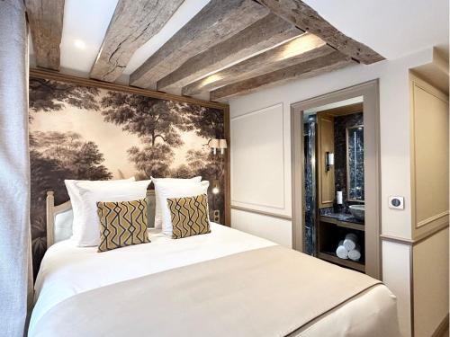 une chambre avec un lit blanc avec un tableau sur le mur dans l'établissement Merveil - Signature Suite - Tour Eiffel - Bourgogne, à Paris