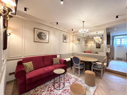 un salon avec un canapé rouge et une table dans l'établissement Merveil - Signature Suite - Tour Eiffel - Bourgogne, à Paris