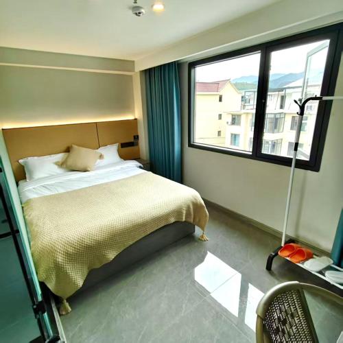 a bedroom with a bed and a large window at Wangxian Valley Qingchuanxingguan - Wangxian Valley Scenic Area in Jiangcun
