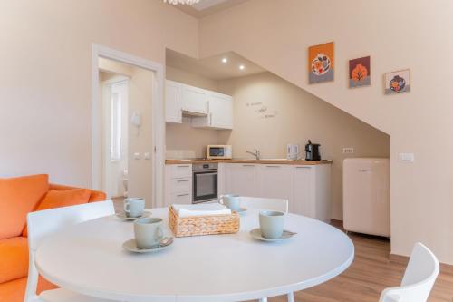 a kitchen and dining room with a white table and chairs at Casa Margherita tra charme e verde in Casorate Sempione