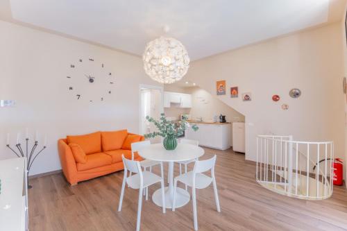 a living room with a table and an orange couch at Casa Margherita tra charme e verde in Casorate Sempione