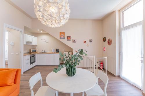 a white dining room with a white table with a plant on it at Casa Margherita tra charme e verde in Casorate Sempione