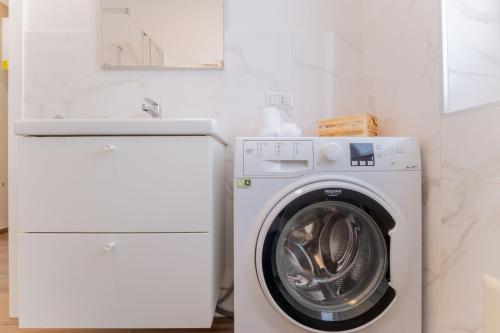 a white washing machine in a white laundry room at Casa Margherita tra charme e verde in Casorate Sempione