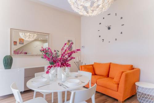 a living room with a table and an orange couch at Casa Margherita tra charme e verde in Casorate Sempione
