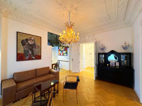 a living room with a couch and a chandelier at 7th HEAVEN Vienna Center Apartments in Vienna