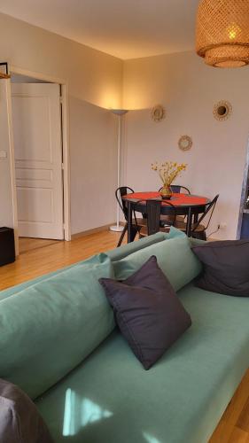 un canapé vert dans un salon avec une table dans l'établissement Appartement plein centre avec terrasse, à Font-Romeu