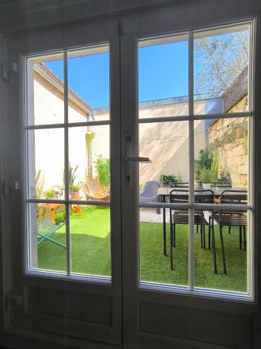 une porte vitrée avec vue sur une table à manger dans l'établissement Les Grumes, Centre Ville, Jardin,Self check-in, FreeWifi, Netflix, à Compiègne