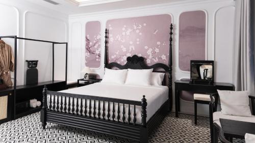 a black and white bedroom with a bed and a chair at The City Boutique Hotel in Bien Hoa