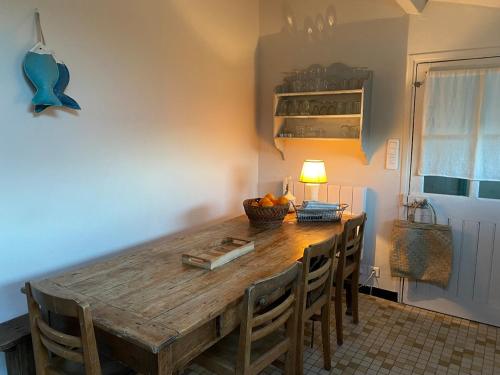 une salle à manger avec une table et des chaises en bois dans l'établissement Ancienne maison de pêcheur, à L'Ile d'Yeu