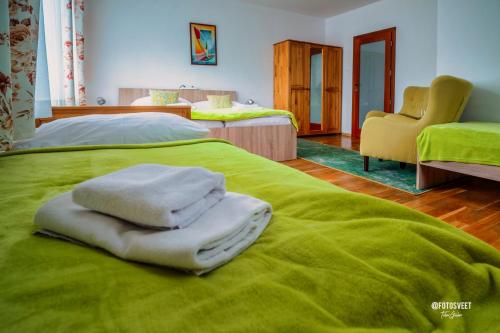 a green bed with towels on top of it at Wellness Penzion Zora Family in Tatranská Lomnica