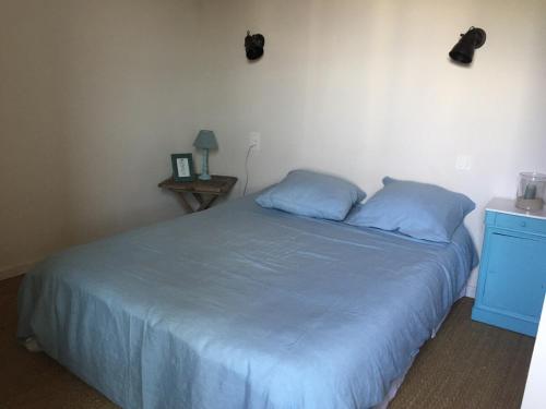 une chambre avec un lit avec des oreillers bleus dans l'établissement Ancienne maison de pêcheur, à L'Ile d'Yeu