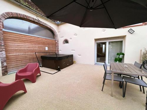 une chambre avec une table, des chaises et un parasol dans l'établissement Logement familial cosy proche d'Auxerre & Chablis, à Vergigny