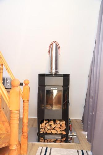 a stove in a room with a pile of wood at Алтын Балык in Toktogul