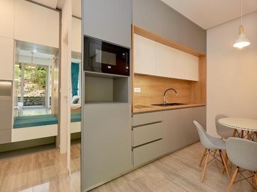 uma cozinha com uma mesa e uma sala de jantar em AURA TOWER Apartments by Gaby em Rafailovici