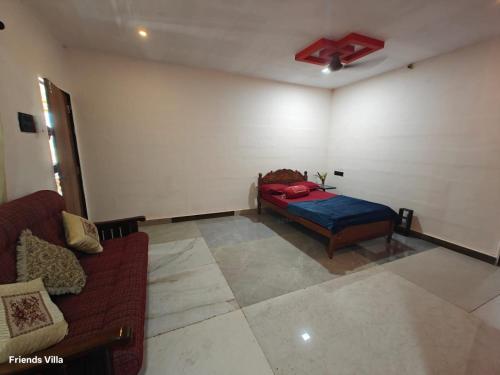 a living room with a bed and a couch at Paradise Farm Alibaug in Kashid