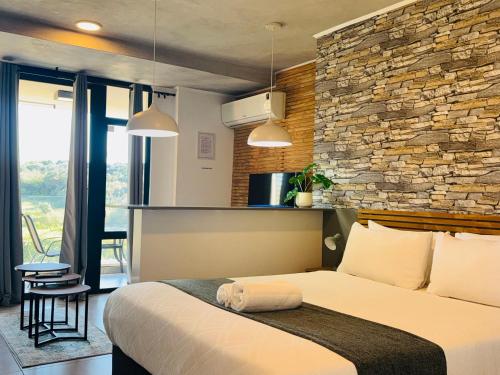 德班Sibaya Coral Point Studio Apartment的一间带床和石墙的卧室