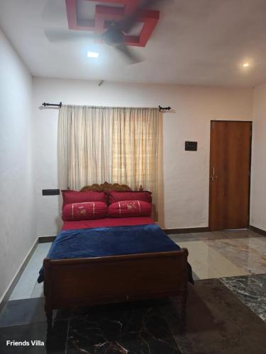 a bedroom with a bed with red pillows and a ceiling fan at Paradise Farm Alibaug in Kashid