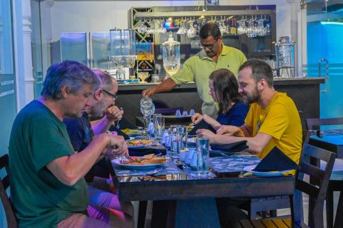 a group of people sitting at a table eating food at WetLand Resort in Negombo
