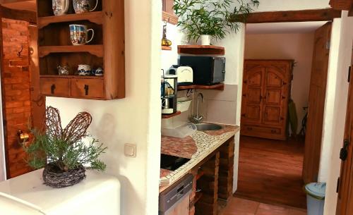 two pictures of a kitchen with a sink and a door at Ferienwohnung Sophienhof in Loitz