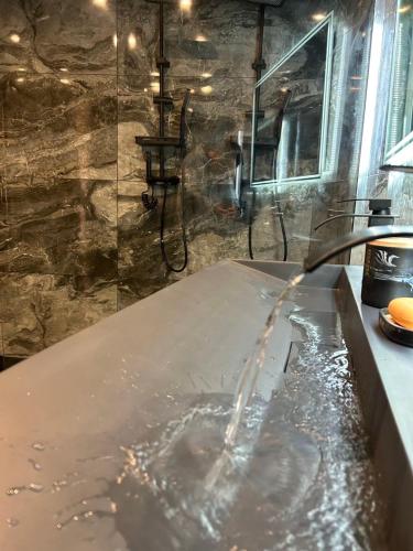 La salle de bains est pourvue d'une baignoire remplie d'eau. dans l'établissement Provençal and modern house, à Grasse