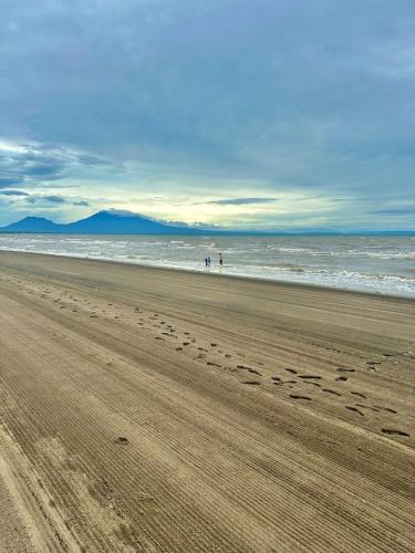 a beach with two people standing in the water at The Calm Nest by Luke and Nian in San Juan