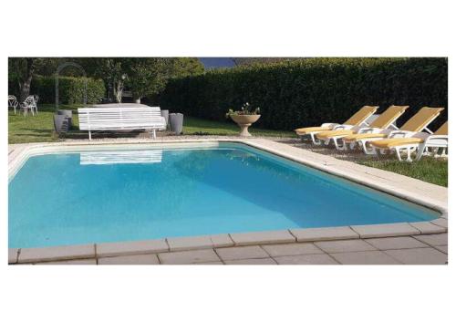 - une piscine avec des chaises longues et un banc dans l'établissement Gite Piscine Périgord, à Saint-Cyprien