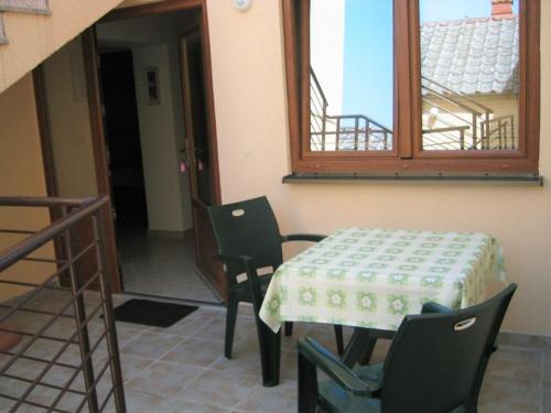 a table and chairs in a room with a window at Alto Mare Apartments in Selce