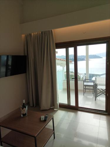 a living room with a table and a large window at VILLA ALEXIS in Megali Ammos