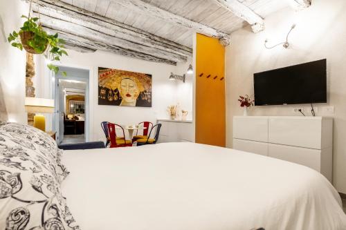 a bedroom with a bed and a flat screen tv at Di Grazia Cagliari - Stile, comfort e storia in Cagliari
