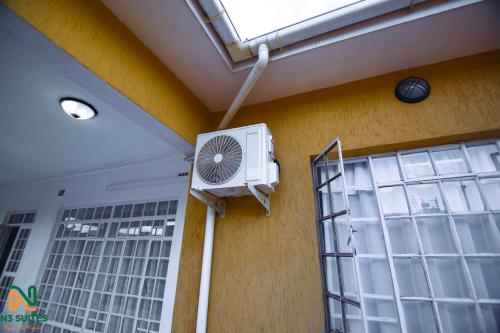 a fan on the side of a building with a window at N3 Luxury Suite in Mzuzu