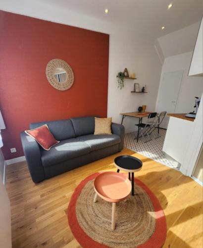 a living room with a couch and a table at Studio Terre - 1st floor - City center - Train station 5 minutes away in Charleville-Mézières
