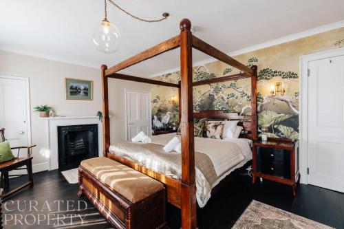 a bedroom with a canopy bed and a fireplace at Central Townhouse with Garden & Free Parking in Bath