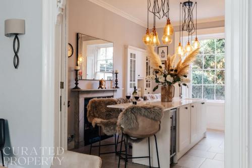 a kitchen with a counter with stools and a mirror at Central Townhouse with Garden & Free Parking in Bath