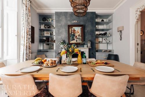 a dining room with a table with food on it at Central Townhouse with Garden & Free Parking in Bath