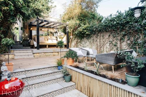 a garden with a table and chairs and a fence at Central Townhouse with Garden & Free Parking in Bath