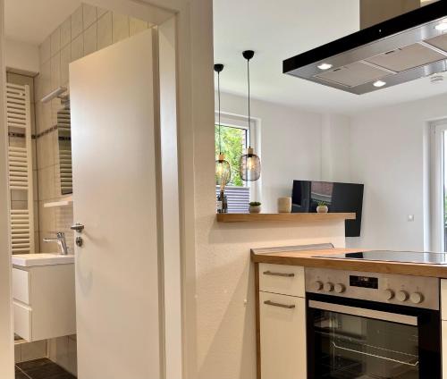 a white kitchen with a stove and a sink at Ferienwohnung Brandung - Haus Seeschwalbe in Schillig