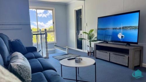 BalmoralにあるBellavista Retreatの青いソファと薄型テレビのあるリビングルーム