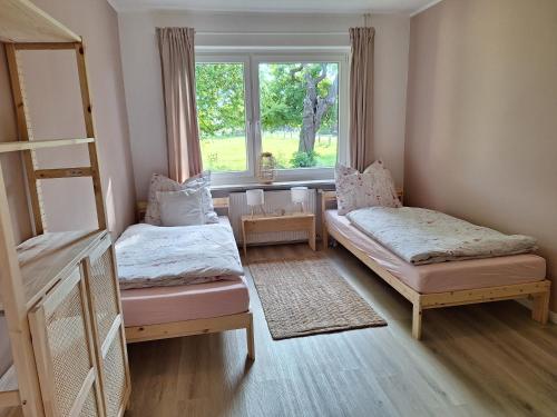 ein Schlafzimmer mit zwei Betten und einem Fenster in der Unterkunft Ferienhaus Landliebe in Riepsdorf