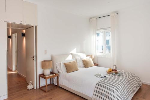a white bedroom with a bed and a window at Luxury Ocean View House - Central Ericeira in Ericeira