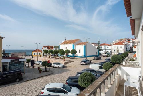 a parking lot with cars parked in a town at Luxury Ocean View House - Central Ericeira in Ericeira