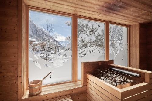 a room with a view of a snow covered mountain at Bio Hotel Stillebach in Sankt Leonhard im Pitztal