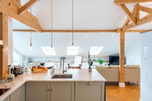 a kitchen and living room with wooden beams at Ocean View Penthouse - Central Ericeira in Ericeira