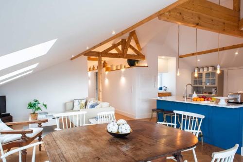 a kitchen and dining room with a wooden table and chairs at Ocean View Penthouse - Central Ericeira in Ericeira