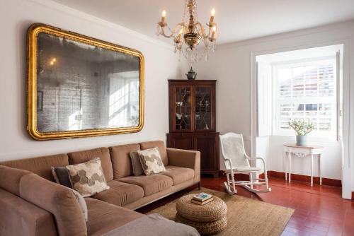 a living room with a couch and a mirror at Central Ericeira Apartment with Lift in Ericeira