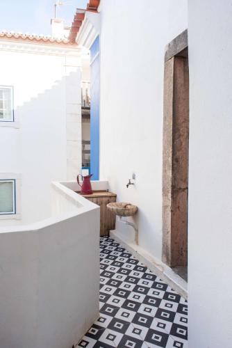 a bathroom with a black and white tiled floor at Central Ericeira Apartment with Lift in Ericeira