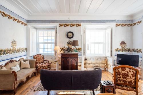 a living room with a couch and a tv at Central 3 Bedroom Apartment in Ericeira in Ericeira