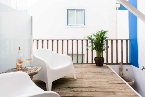 a balcony with a white chair and a plant at Central 3 Bedroom Apartment in Ericeira in Ericeira
