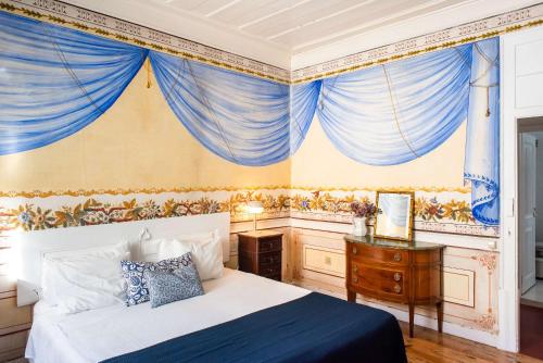 a bedroom with a bed and blue drapes at Central 3 Bedroom Apartment in Ericeira in Ericeira