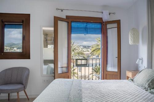 a white bedroom with a bed and a balcony at B&B Mirazul in Peniscola