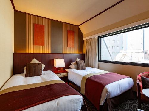 Postel nebo postele na pokoji v ubytování Shibuya Creston Hotel